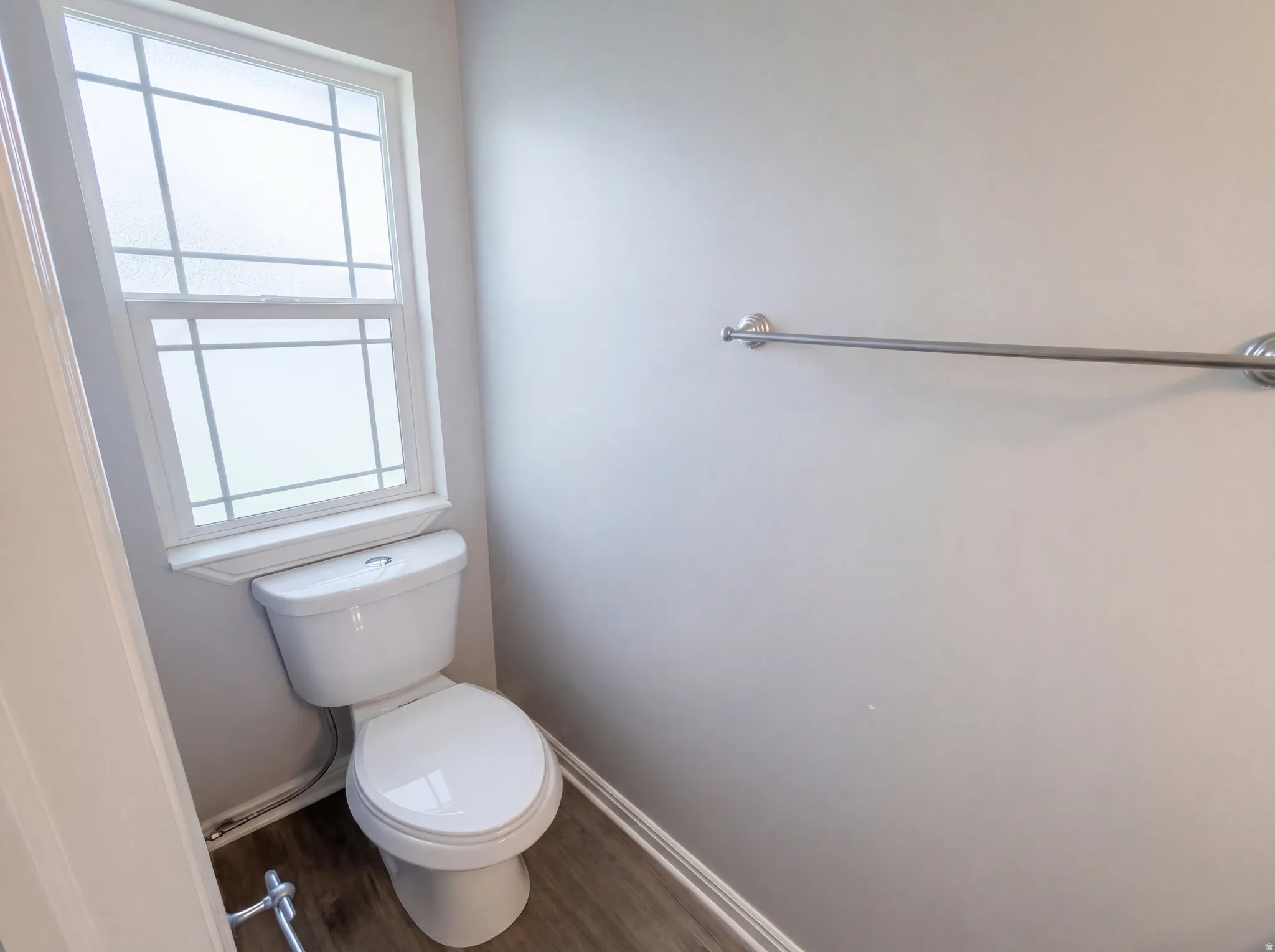 Bathroom featuring dark wood-type flooring and toilet