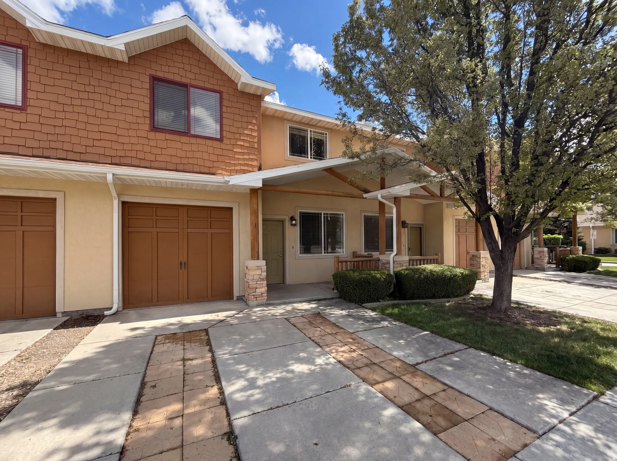 View of front of home with covered porch, stucco siding, and a garage