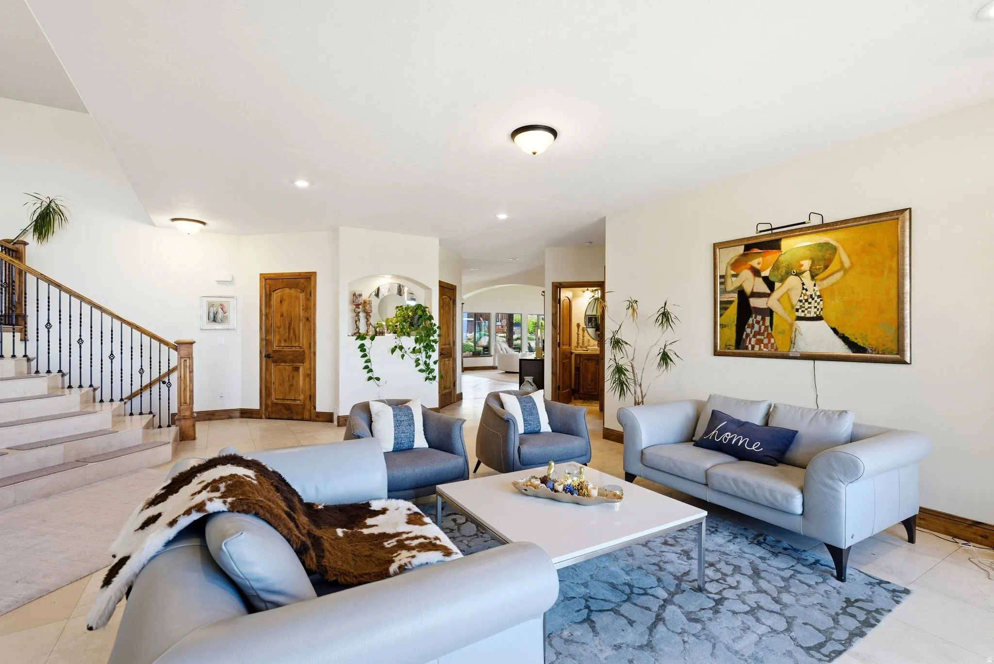 Living area with arched walkways, light tile patterned flooring, and recessed lighting