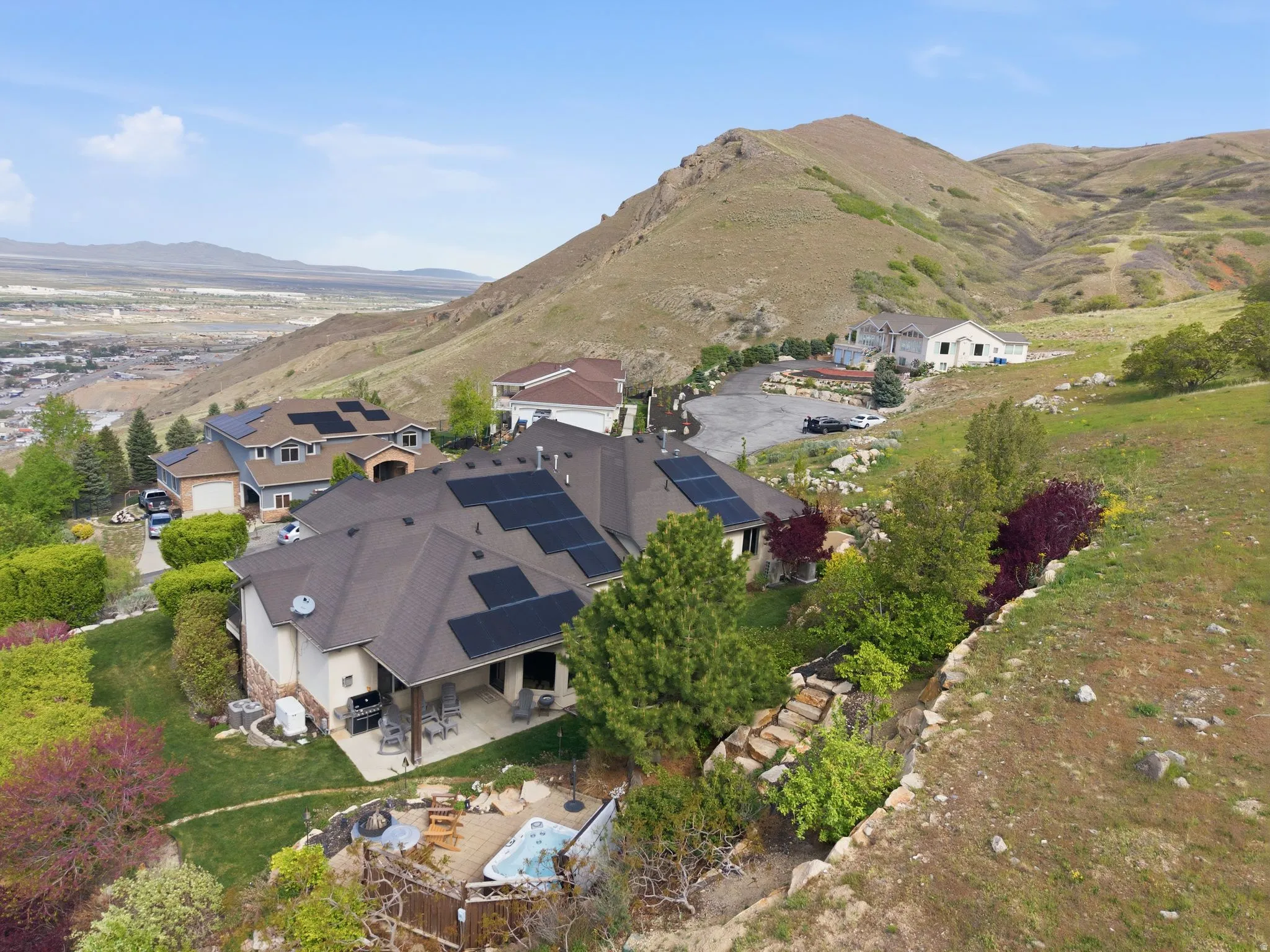 Aerial view of property and surrounding area with a mountain backdrop and nearby suburban area