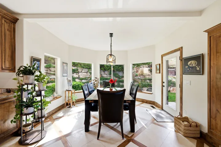 Dining room featuring inlaid floor details and beamed ceiling
