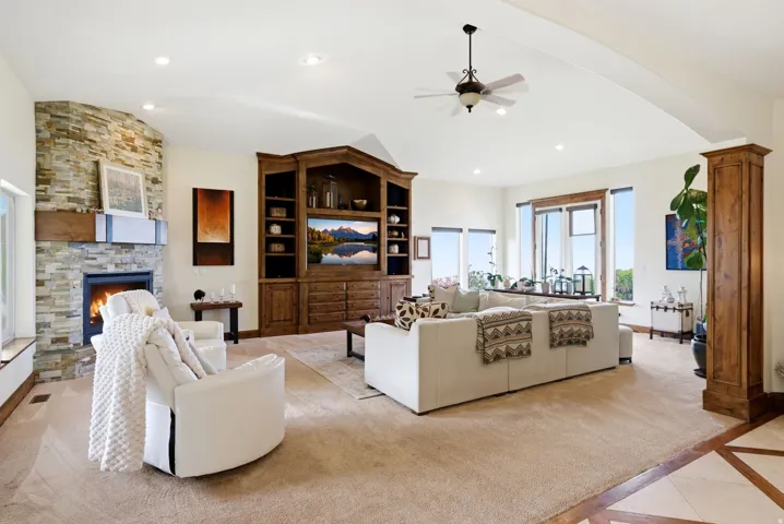 Living area with ceiling fan, a fireplace, inlaid floor details, lofted ceiling, and recessed lighting