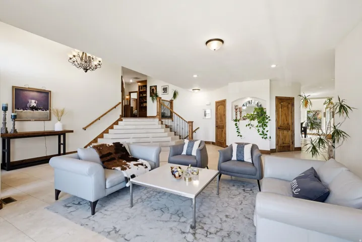 Living room with light tile patterned floors and suspended lighting