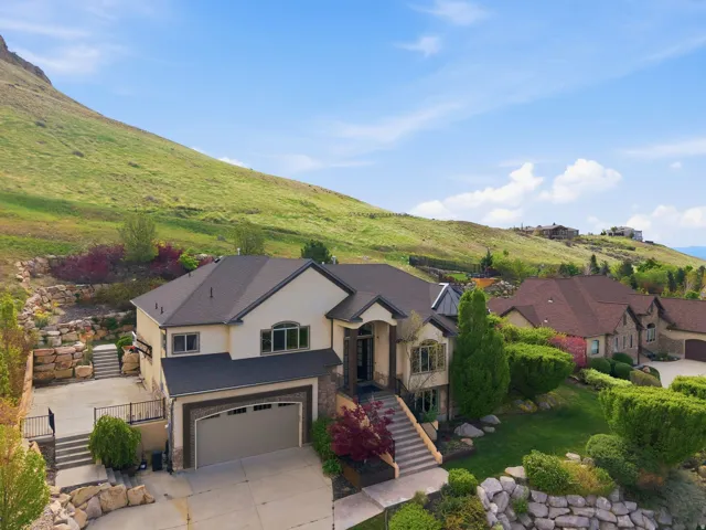 View of front of house featuring stucco siding, a garage, concrete driveway, and a mountain view