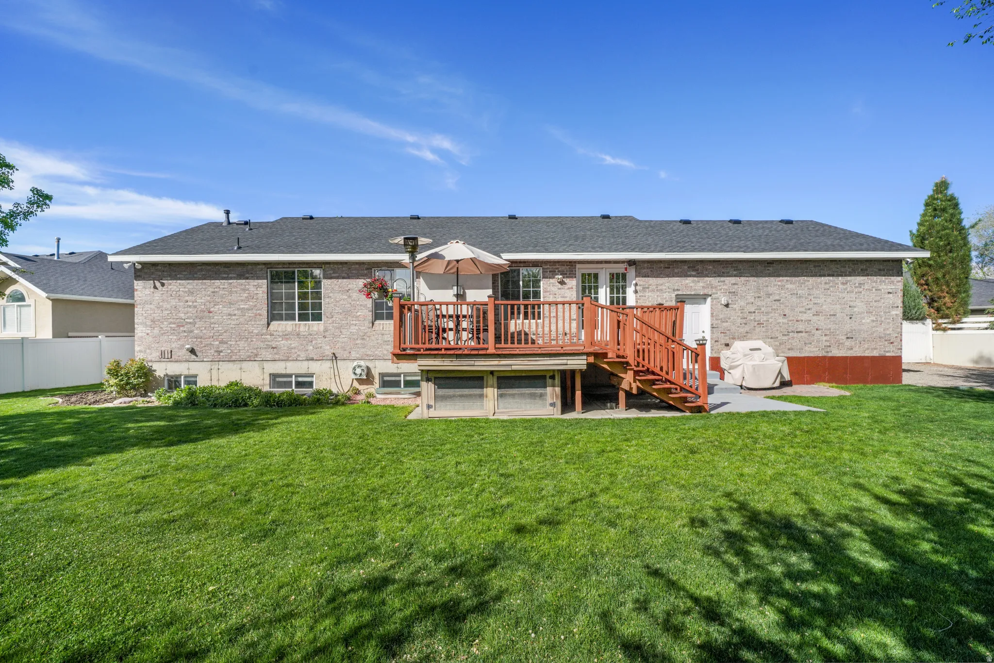 Rear view of property featuring a patio, a deck, and brick siding