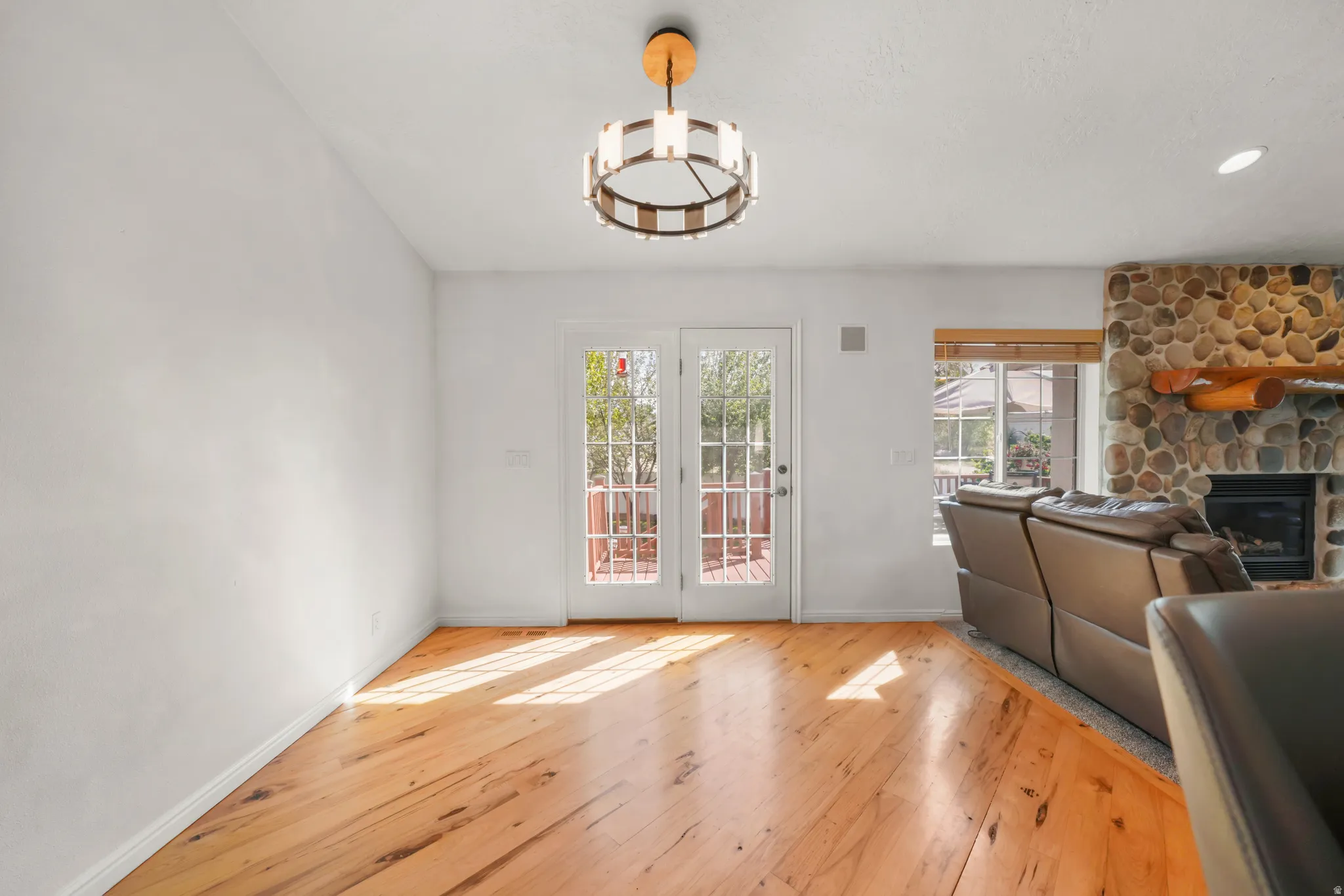 Dining room with light wood-type flooring, healthy amount of natural light, a fireplace, and a chandelier
