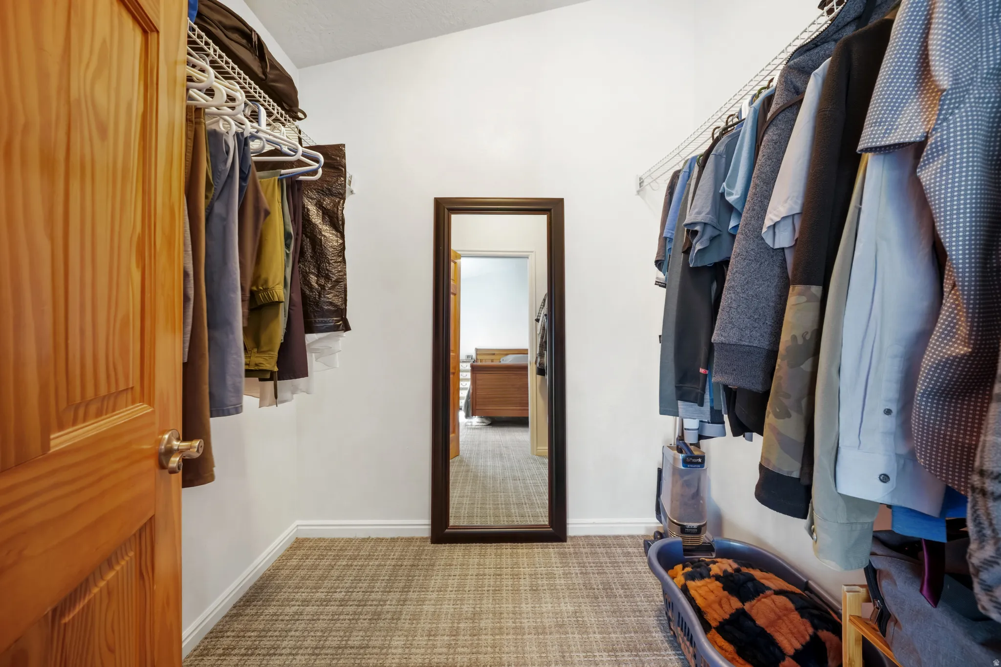 Master walk in closet with light colored carpet