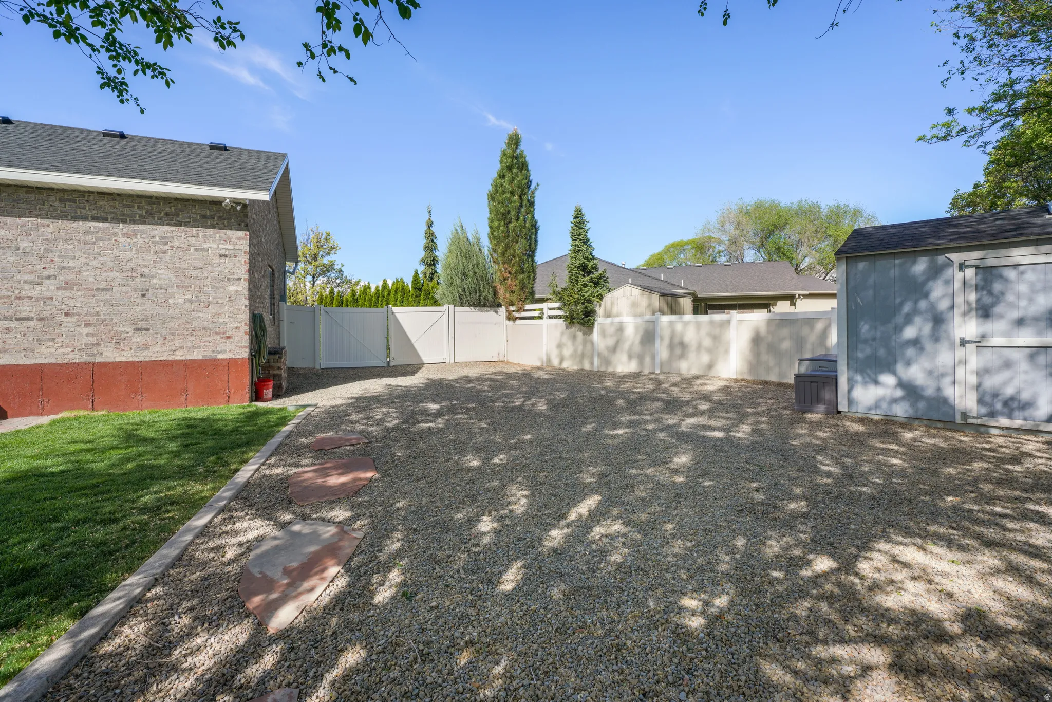 Fenced backyard with a storage shed and a gate