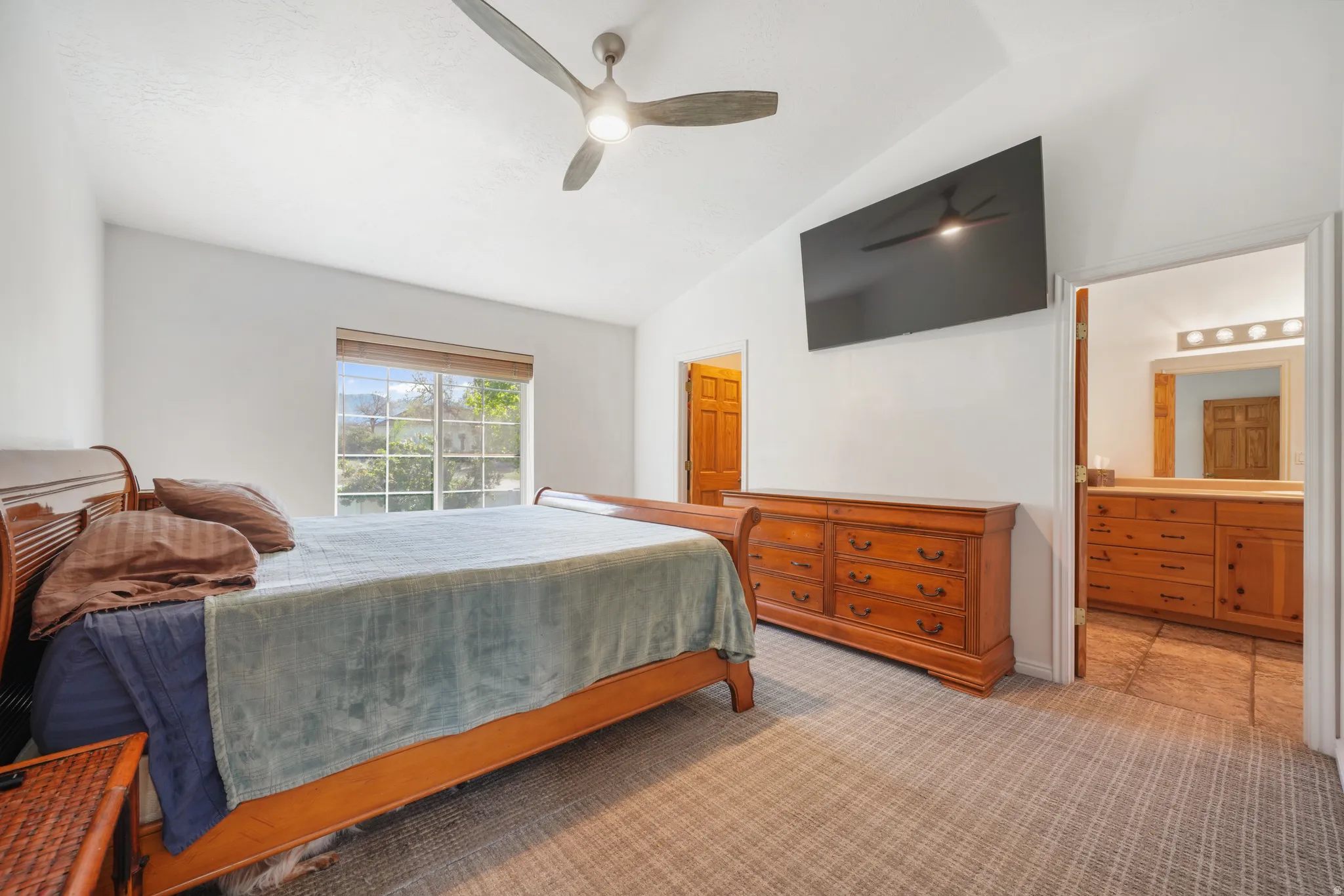 Master Bedroom featuring lofted ceiling, light colored carpet, and ceiling fan
