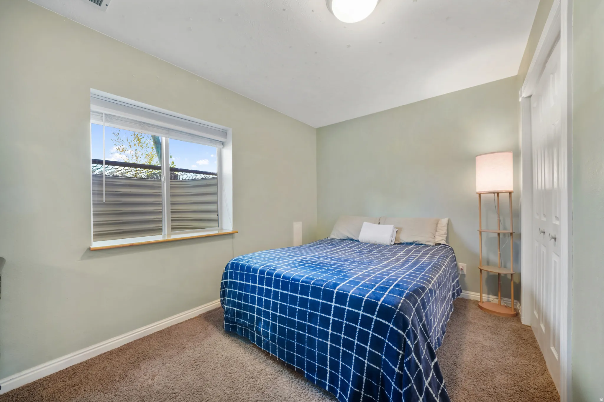 Carpeted bedroom with a closet and baseboards