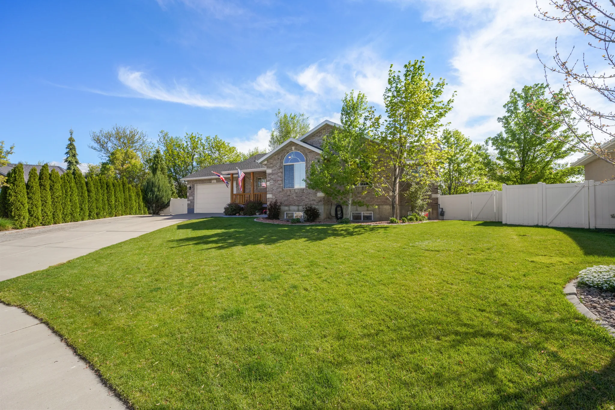 View of front of home featuring a gate, concrete driveway, a garage, and brick siding