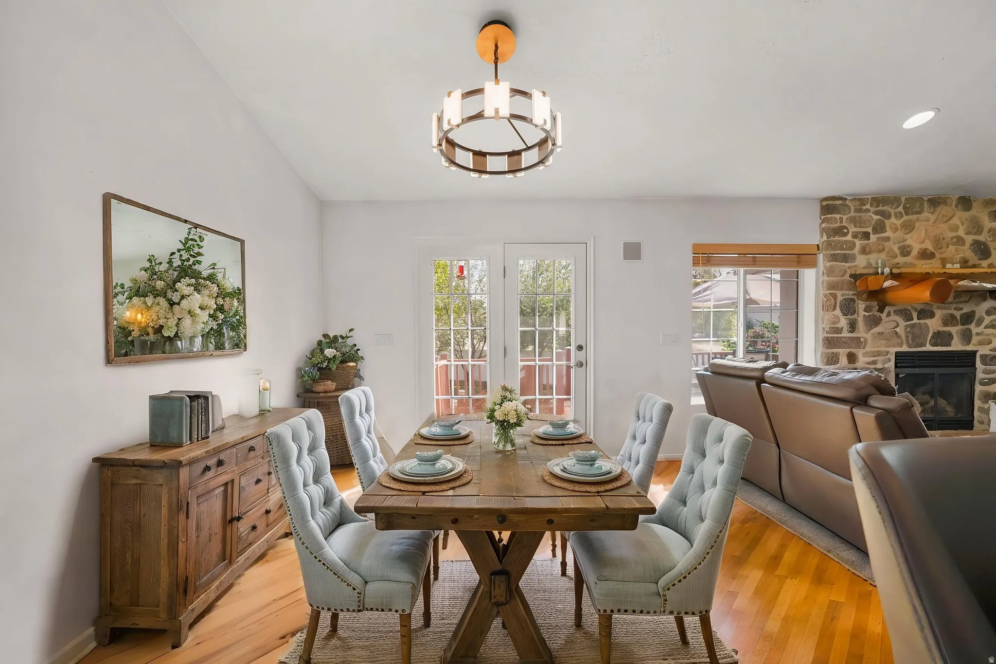 Virtual Image~! Dining area with light wood finished floors, plenty of natural light, a stone fireplace, and suspended lighting