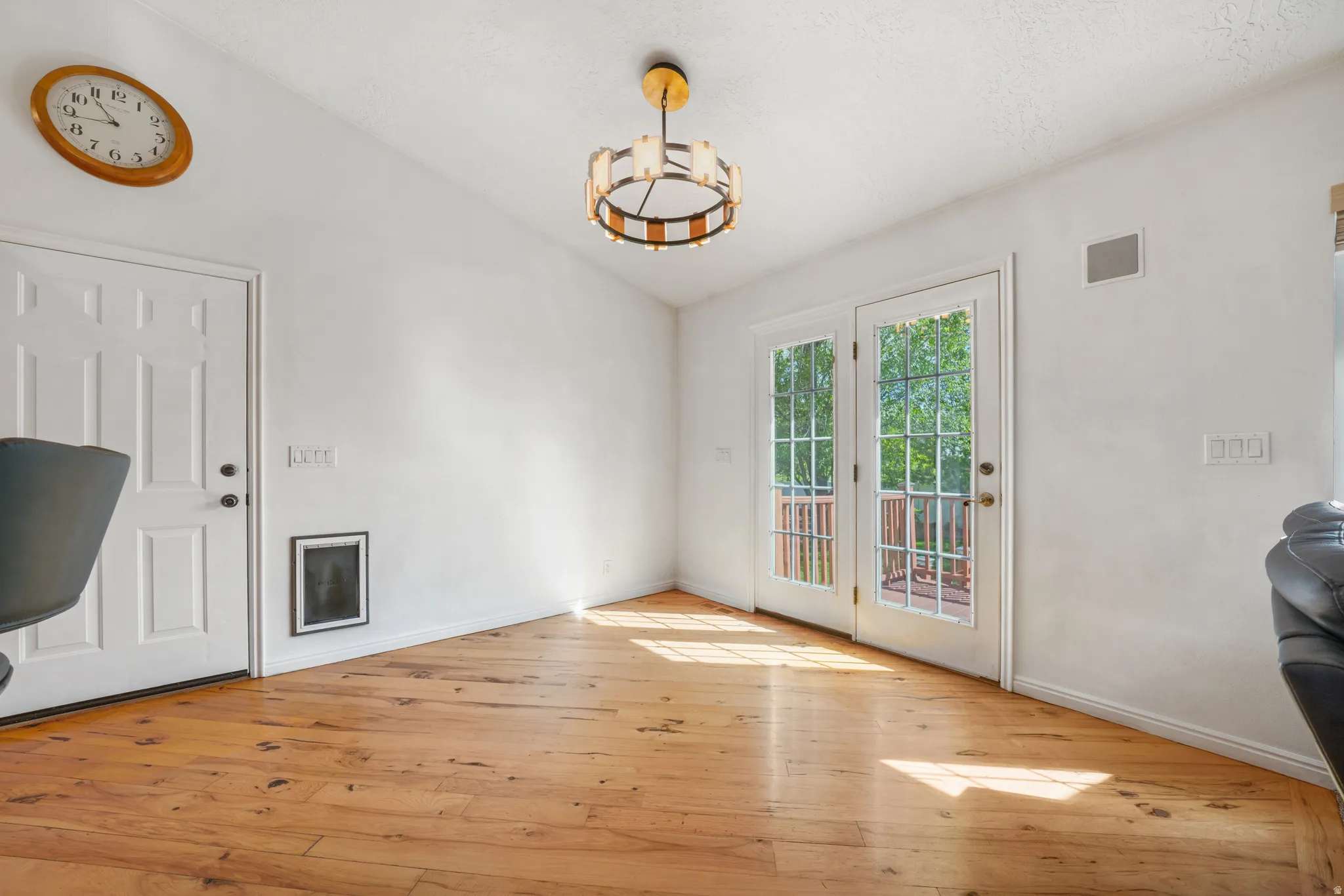 Doorway to outside with vaulted ceiling, hardwood / wood-style flooring, and hanging lights