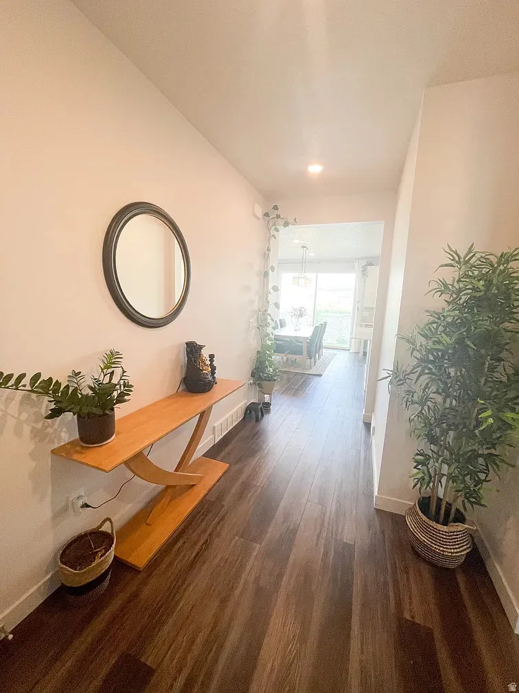 Hall featuring dark wood-type flooring and recessed lighting