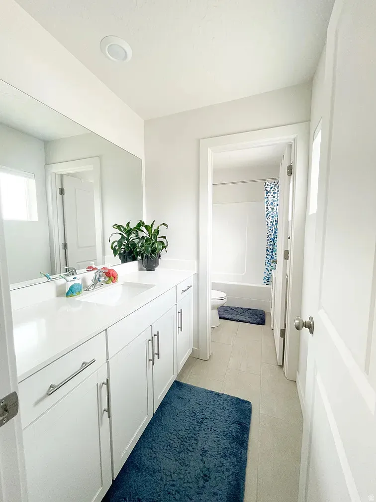 Bathroom featuring vanity, shower / tub combo, and light tile patterned floors