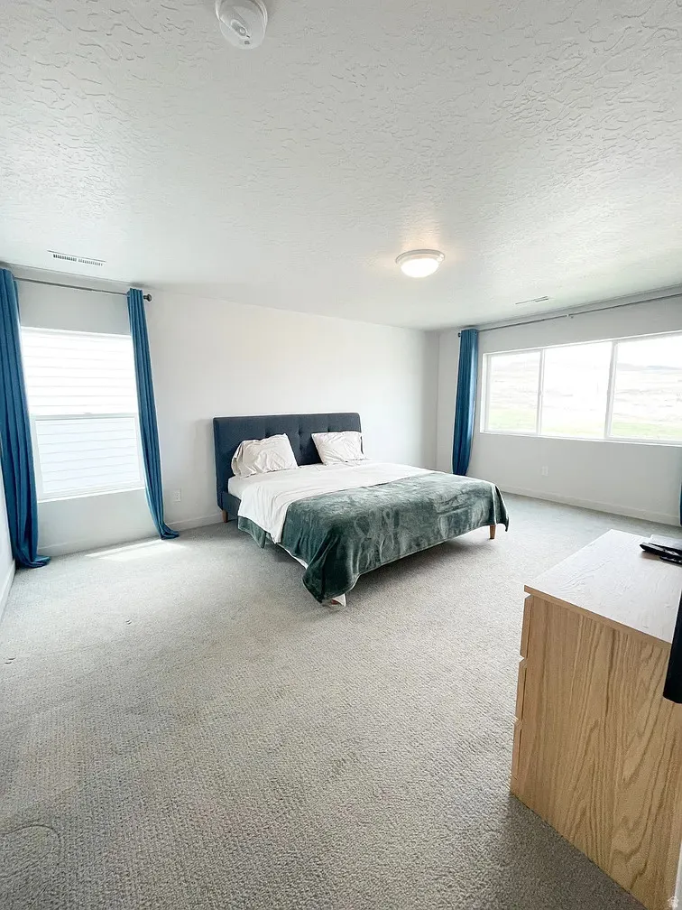 Bedroom featuring a textured ceiling and light carpet