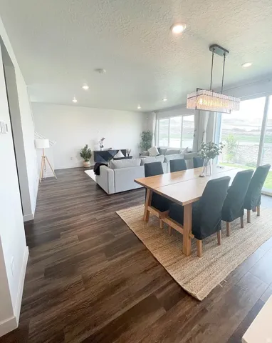Dining room with a textured ceiling, dark wood-type flooring, and recessed lighting