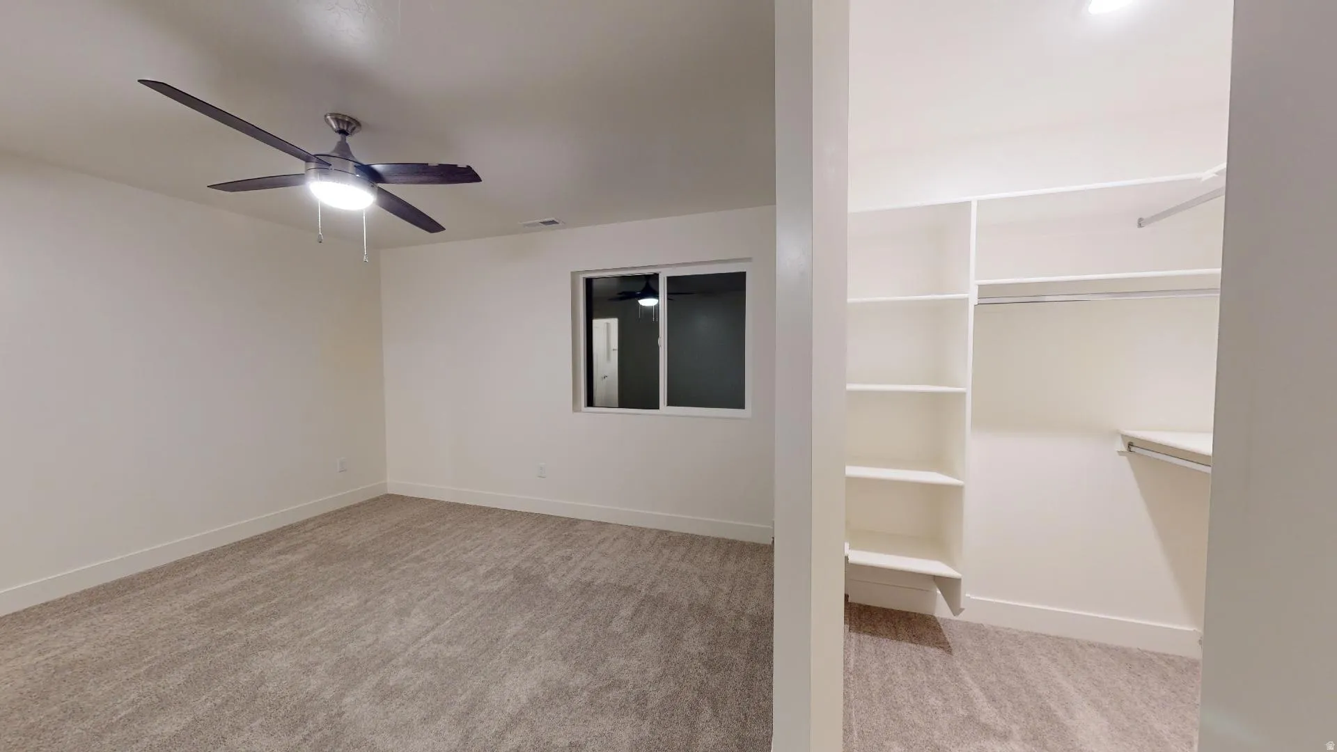 Empty room with light carpet and ceiling fan