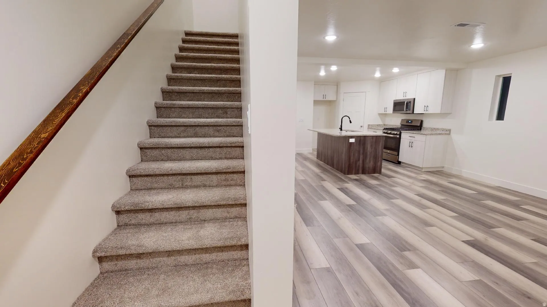 Staircase featuring wood finished floors and recessed lighting