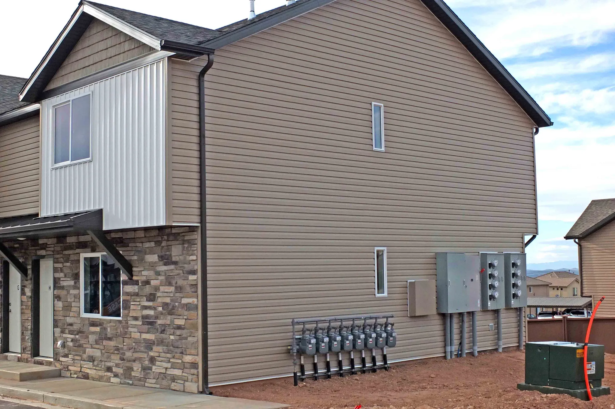View of side of property featuring stone siding and a shingled roof