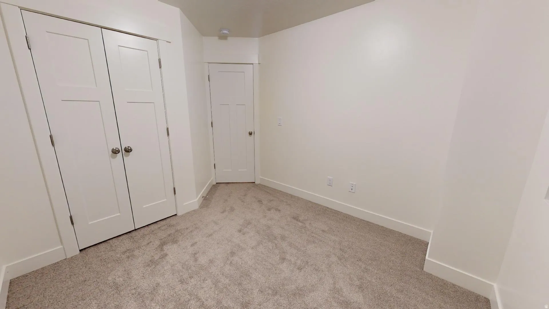 Unfurnished bedroom with light colored carpet and a closet