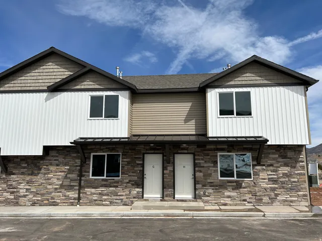 Craftsman inspired home featuring a porch, a standing seam roof, and stone siding