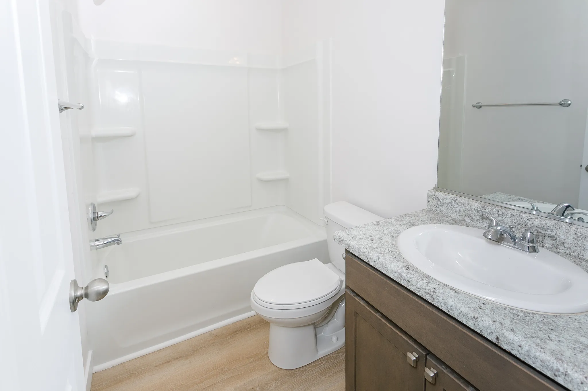 Bathroom featuring vanity, light wood-type flooring, and washtub / shower combination