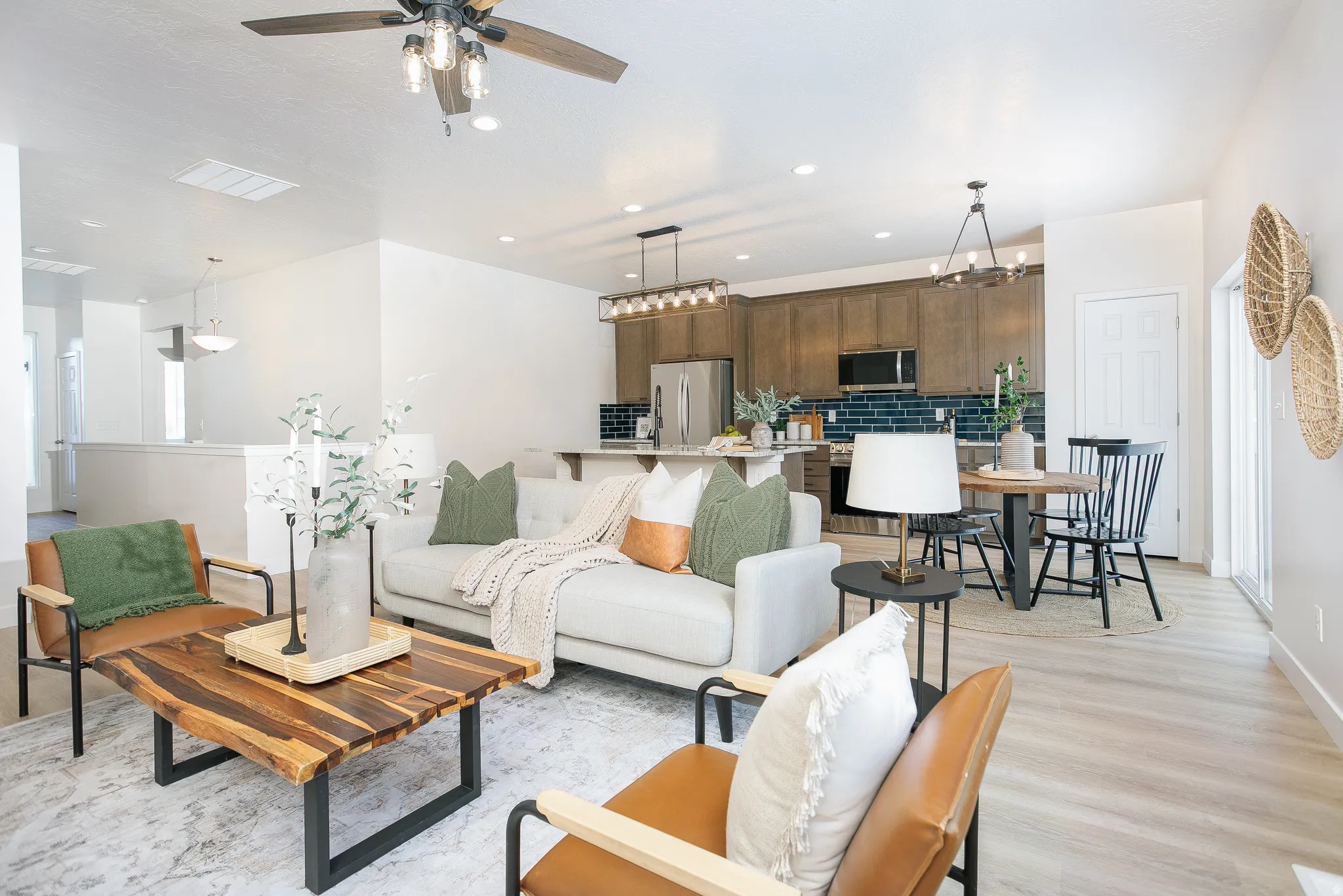 Living area with a ceiling fan, light wood-style floors, and hanging lights