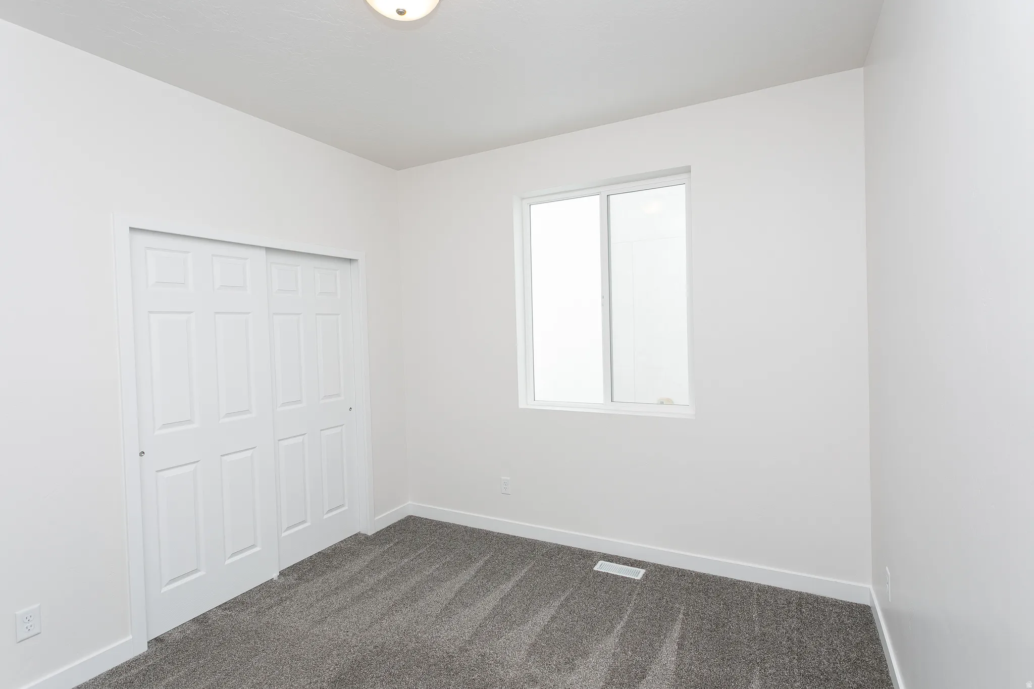 Unfurnished bedroom with dark carpet and a closet