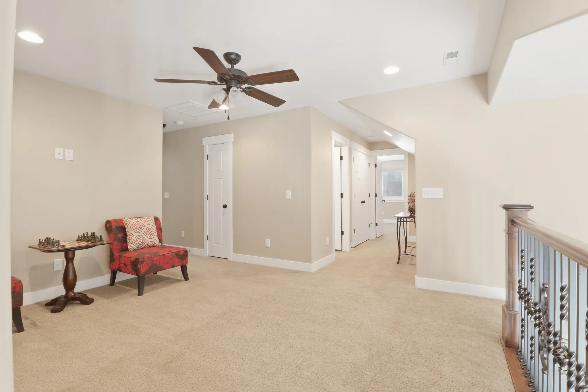 Loft area with recessed lighting, ceiling fan, and light carpet