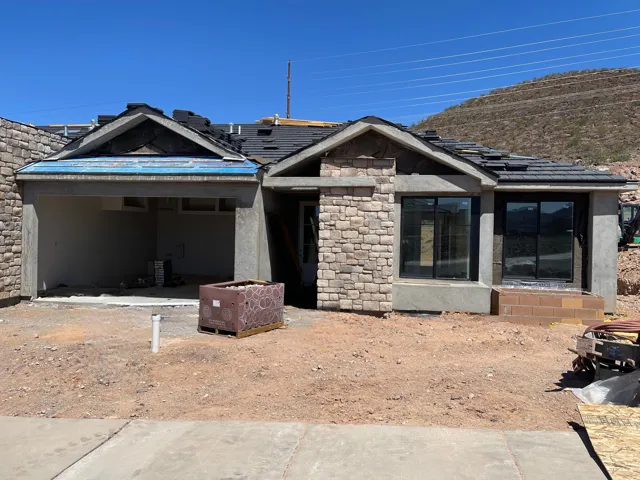 View of front of house featuring stone siding and solar panels