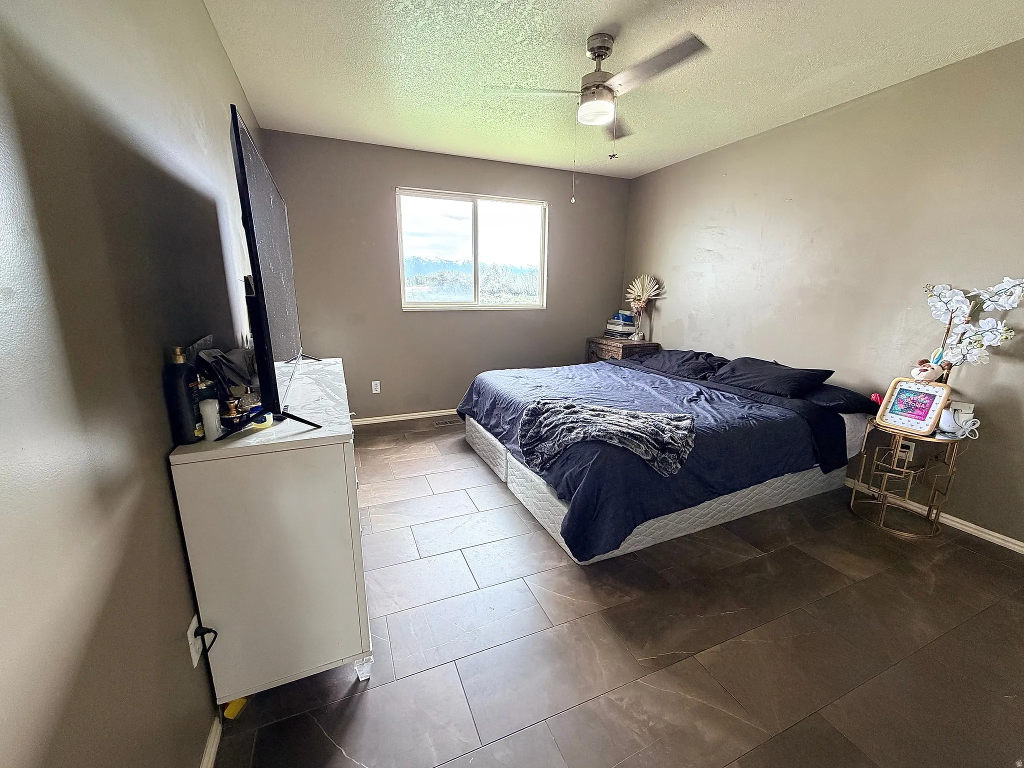 Bedroom featuring ceiling fan and a textured ceiling