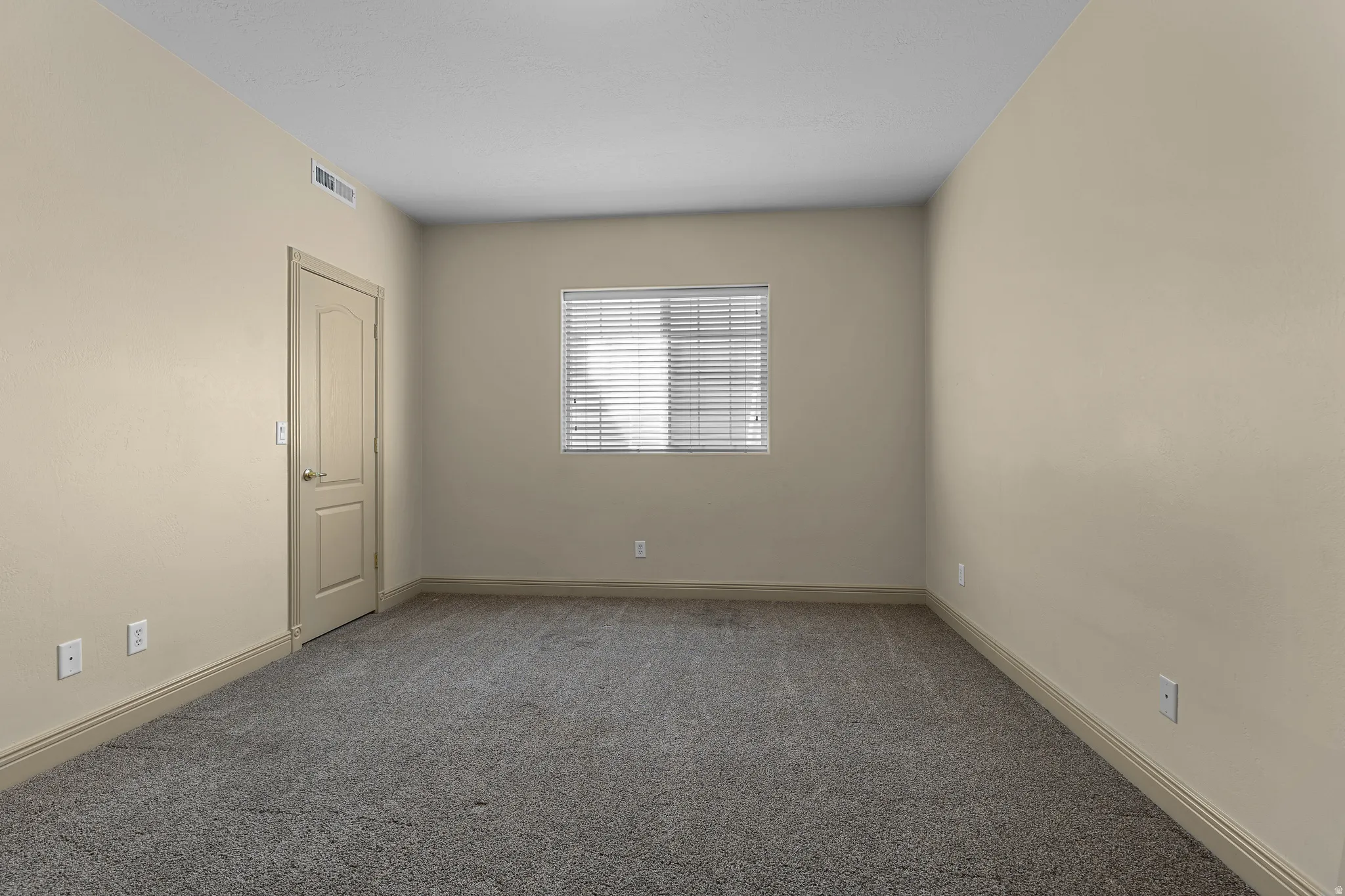 Carpeted empty room with baseboards