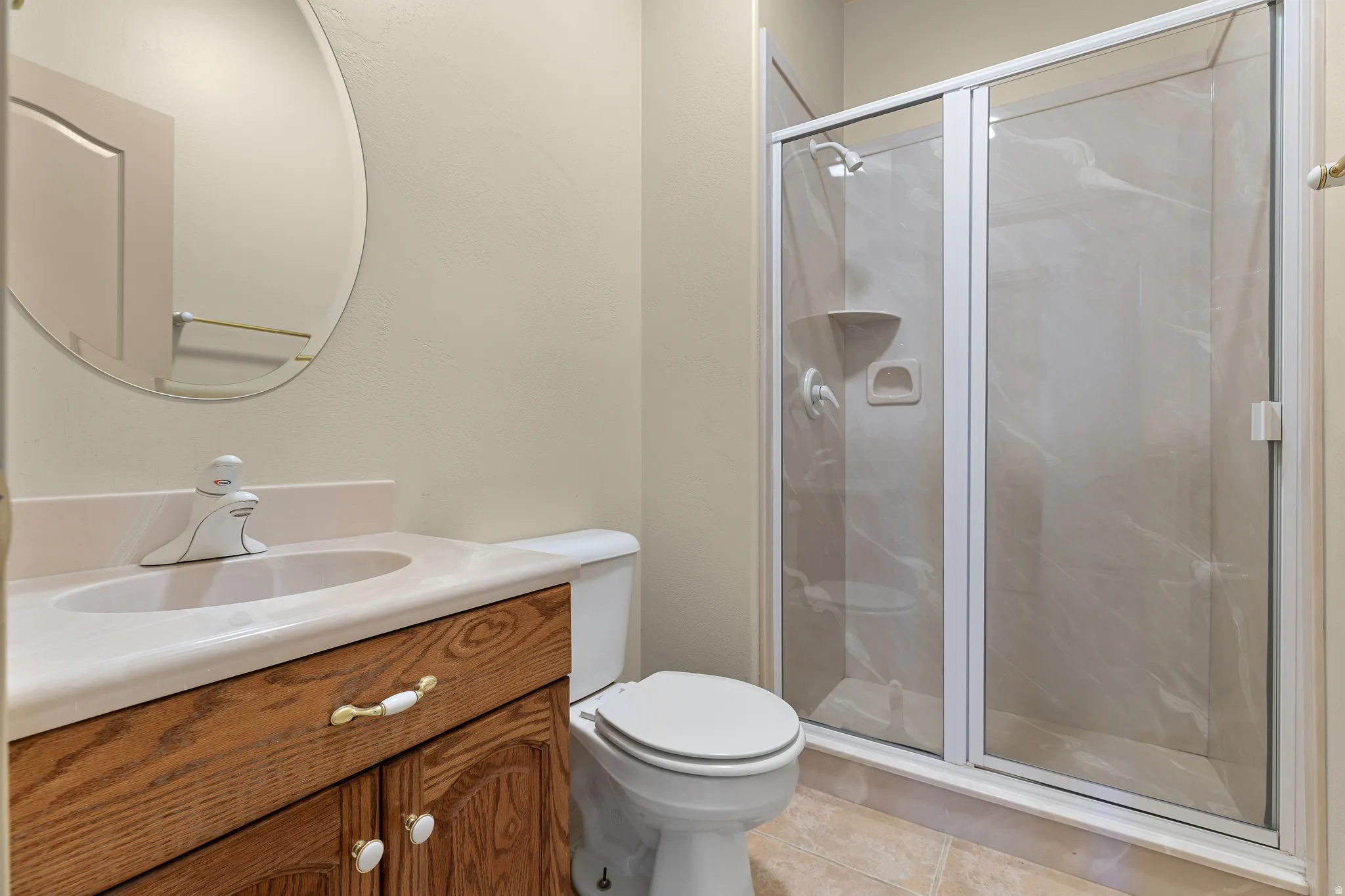 Bathroom with vanity, a shower stall, and light tile patterned floors