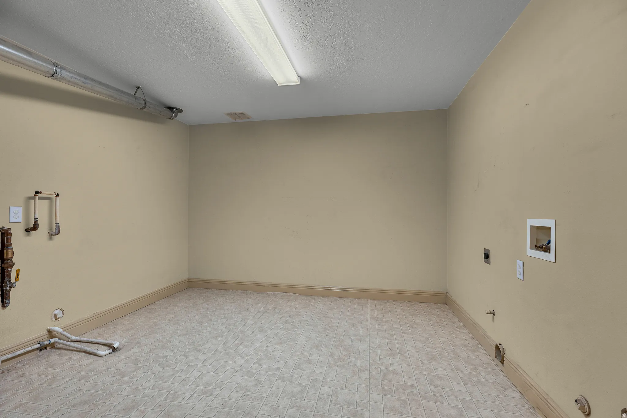 Laundry area featuring hookup for a gas dryer, hookup for a washing machine, electric dryer hookup, and a textured ceiling