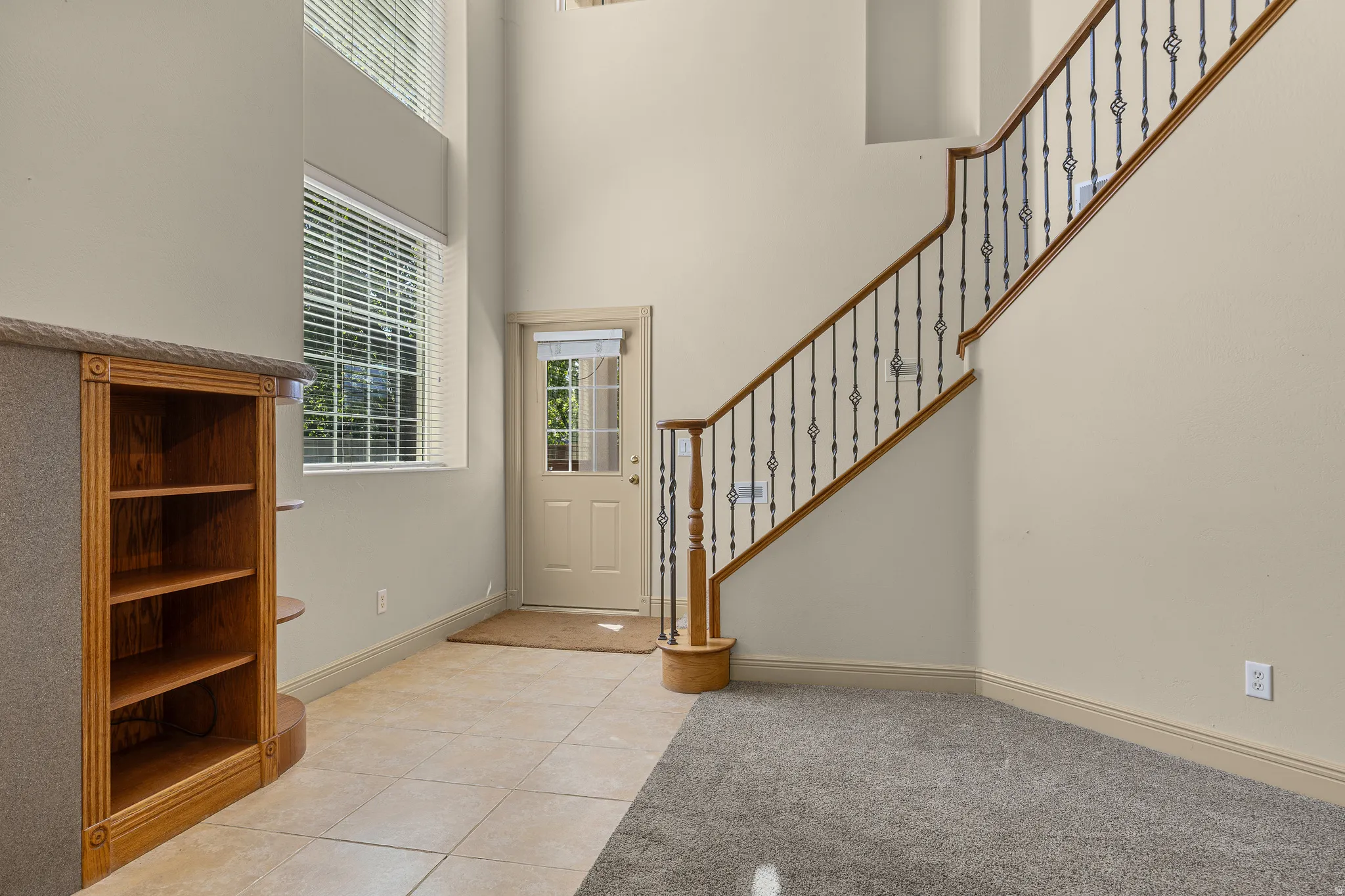 Entryway with light tile patterned floors and a high ceiling