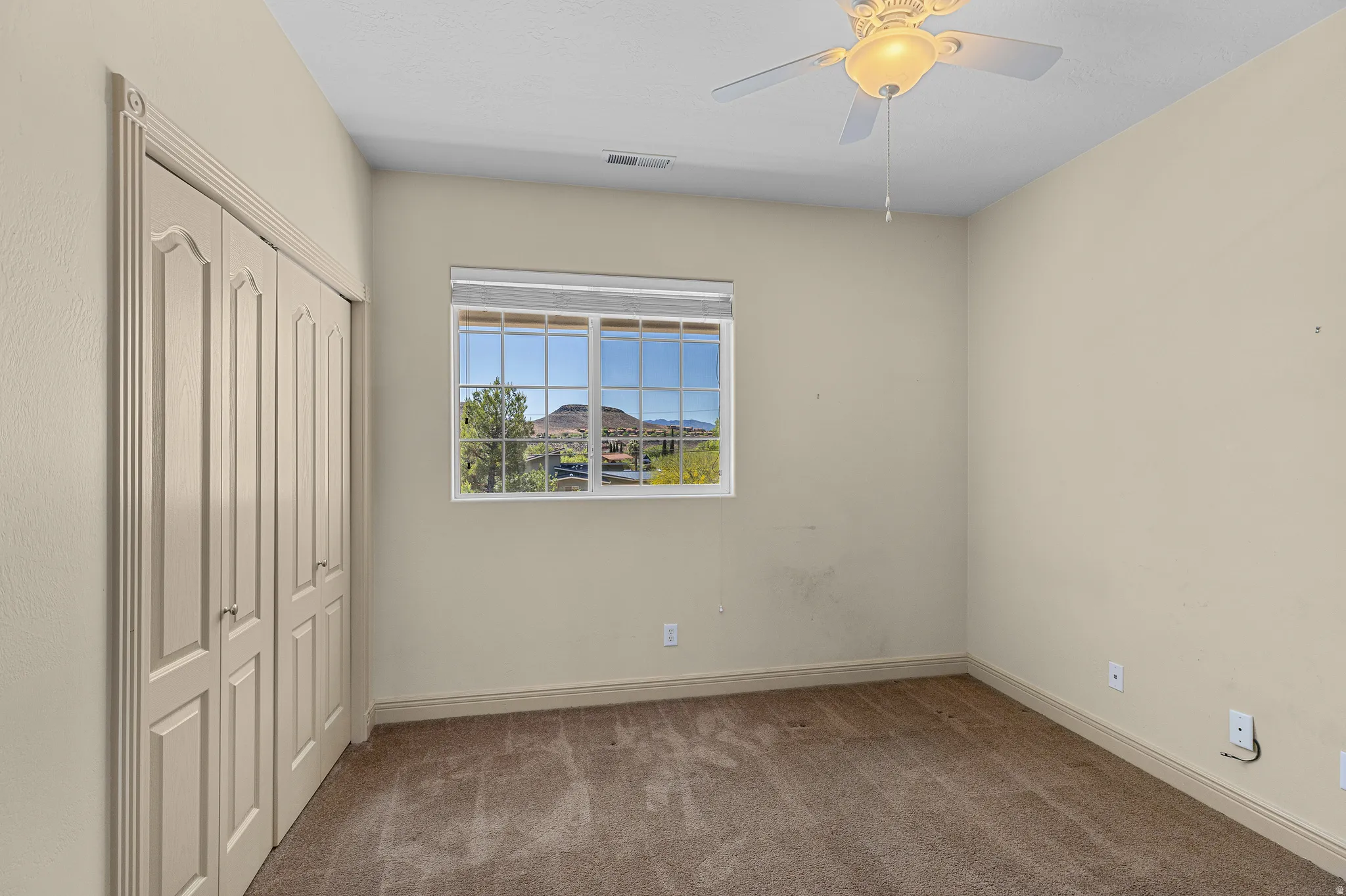 Unfurnished bedroom with carpet floors, a closet, and a ceiling fan