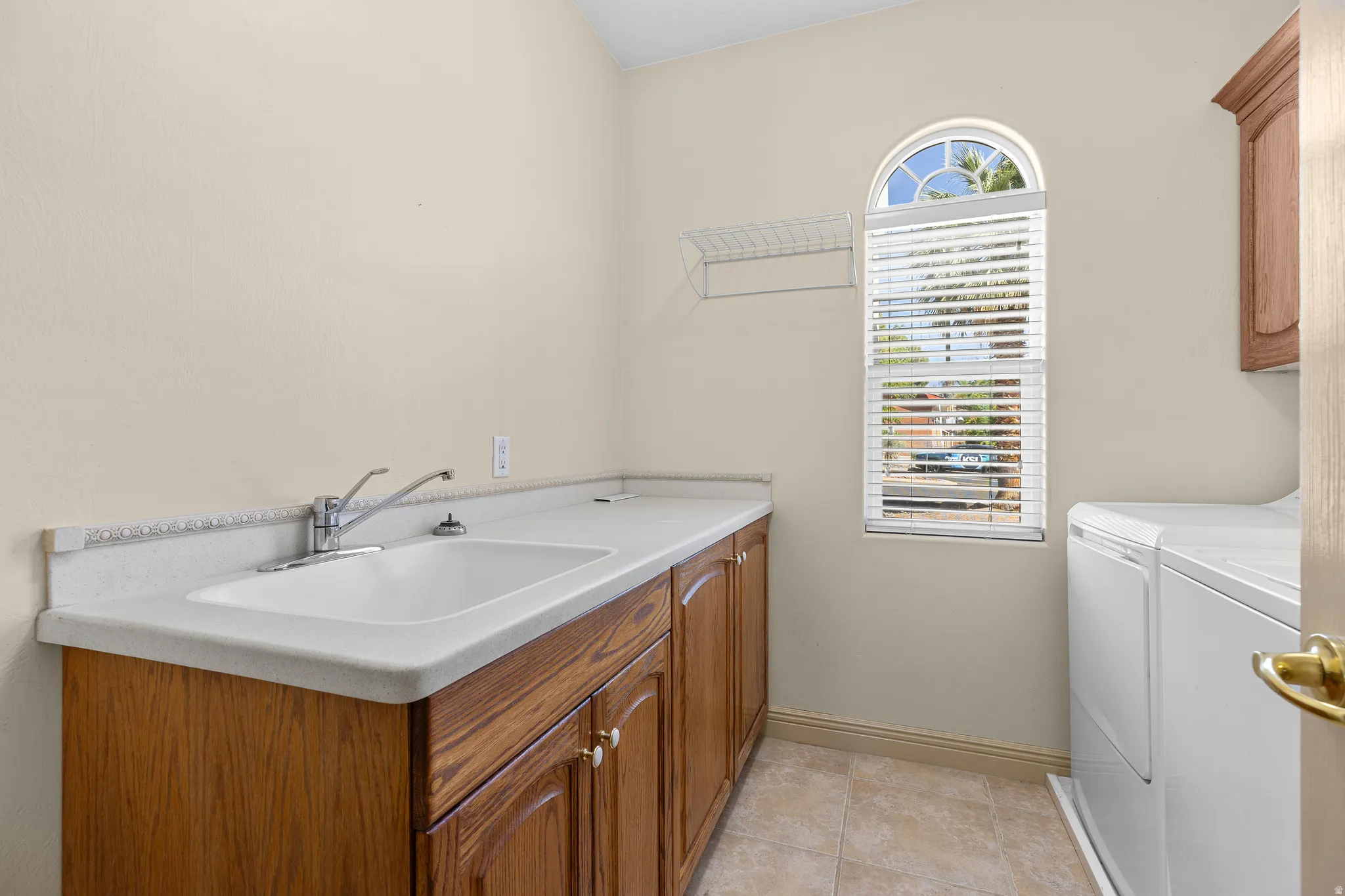 Laundry room featuring washer and clothes dryer, cabinet space, and light tile patterned floors