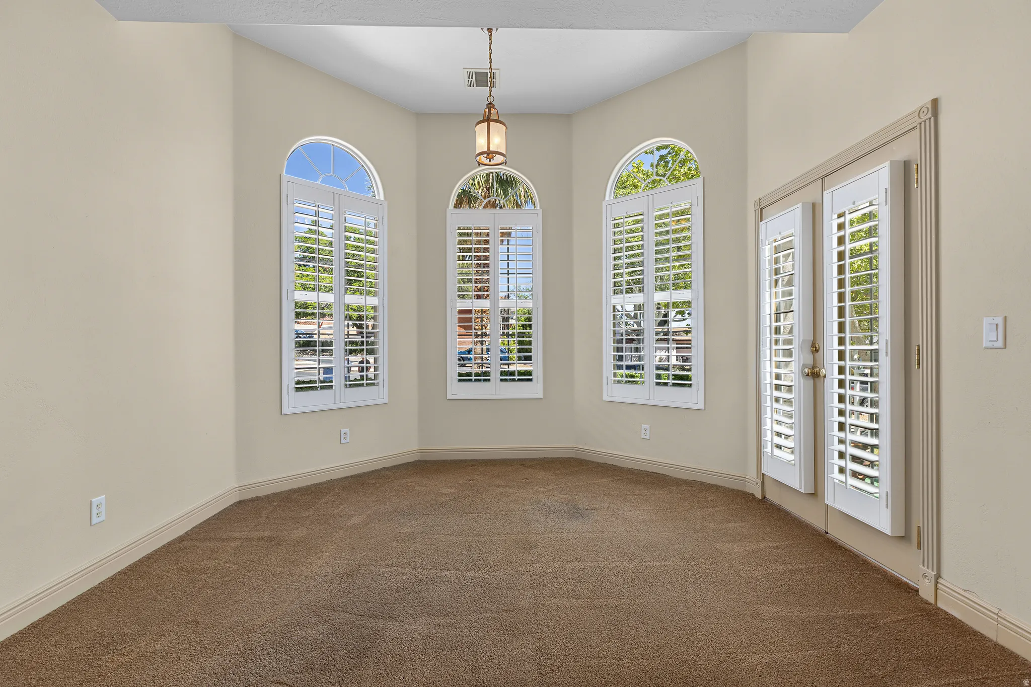 Unfurnished room with dark colored carpet and baseboards