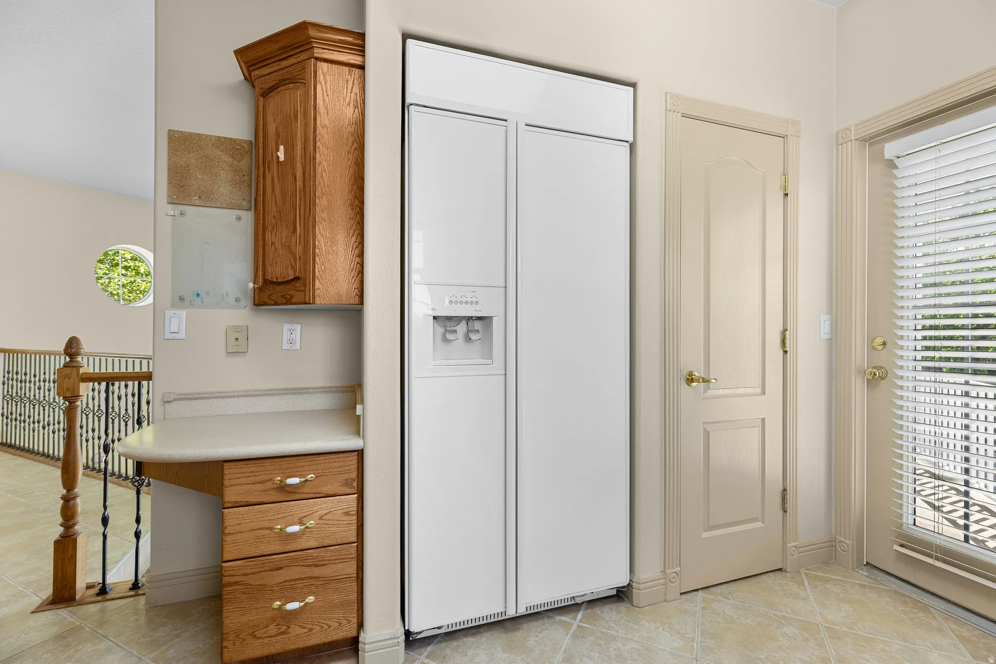 Kitchen with paneled built in refrigerator, wood finish cabinets, light countertops, and light tile patterned floors