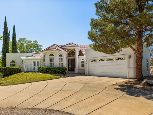 Mediterranean / spanish-style house featuring driveway, stucco siding, and an attached garage