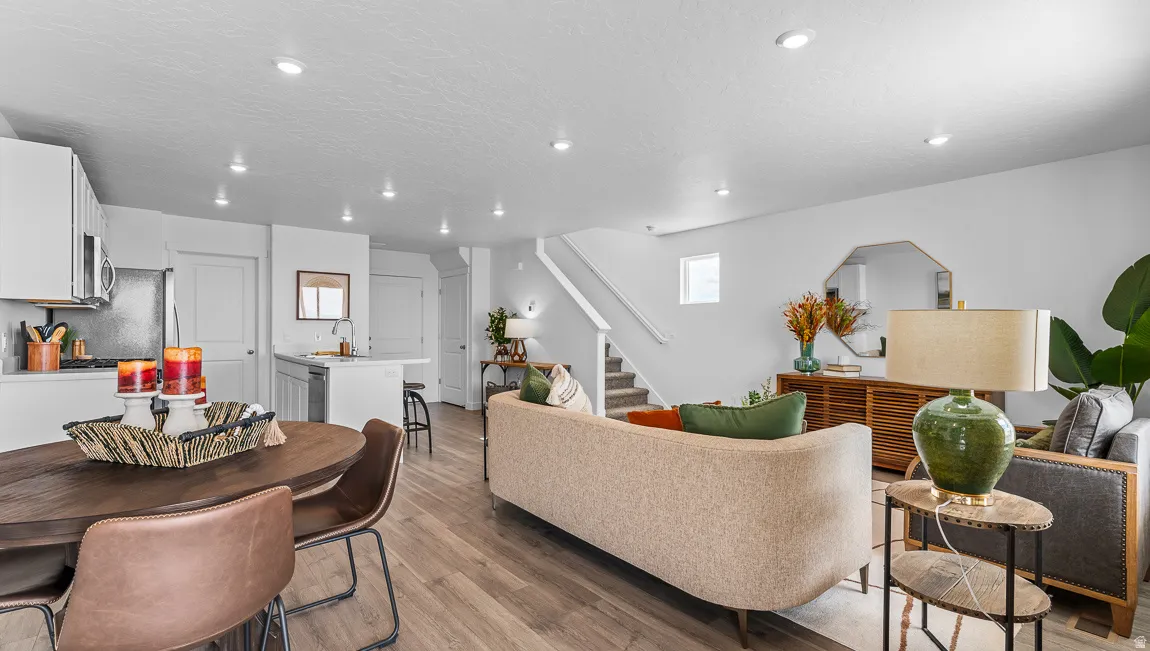 Living room featuring light wood-style flooring, a textured ceiling, and recessed lighting