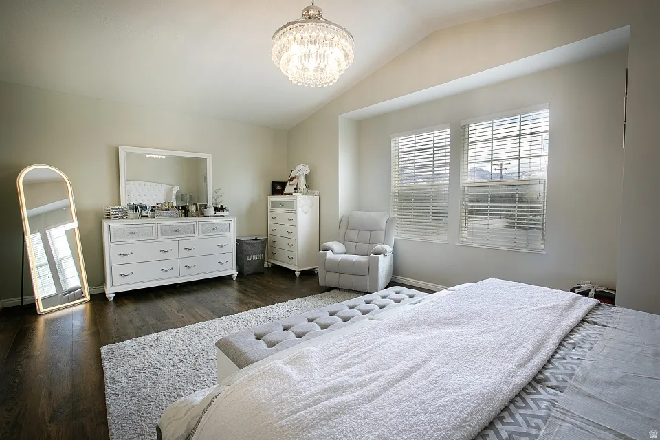 Bedroom with vaulted ceiling,and a chandelier.