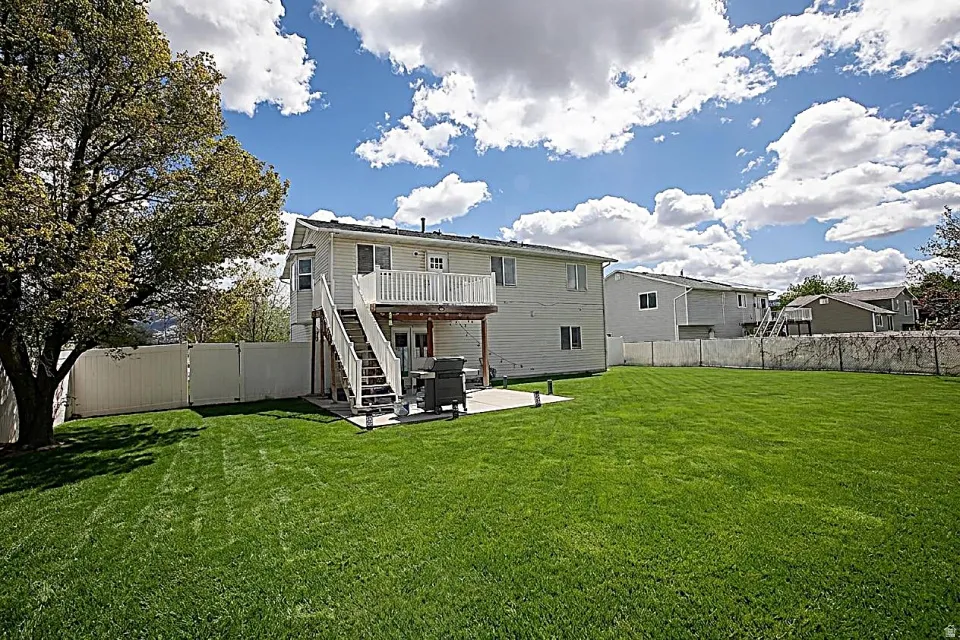 Back of house with a patio, a fenced backyard, and a large, beautiful deck.
