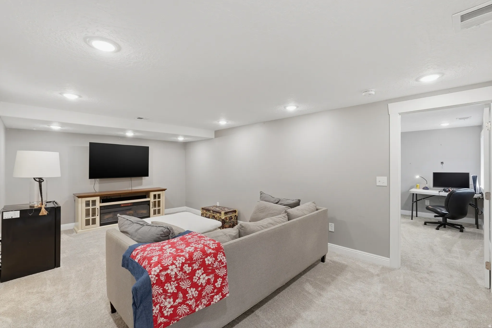 ADU lower level family room with an office area, light colored carpet, recessed lighting, and a fireplace