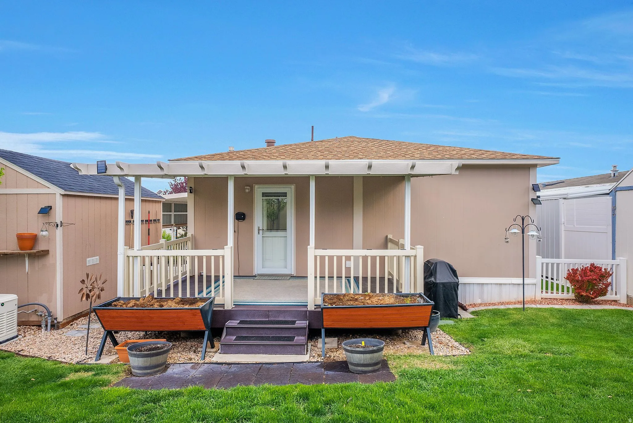 Back of house featuring roof with shingles, a porch, and stucco siding