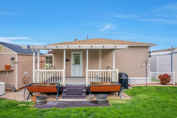 Back of house featuring roof with shingles, a porch, and stucco siding