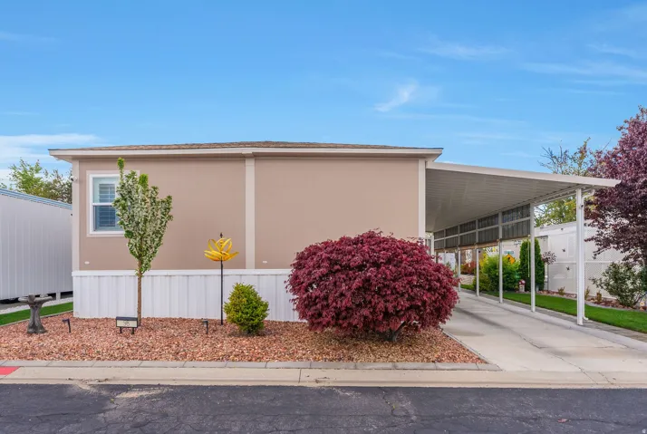 View of side of property with an attached carport and concrete driveway