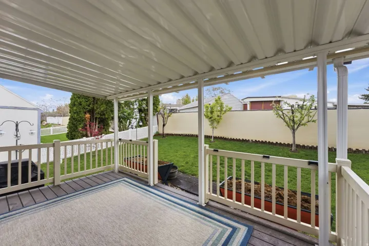 Wooden terrace with a fenced backyard
