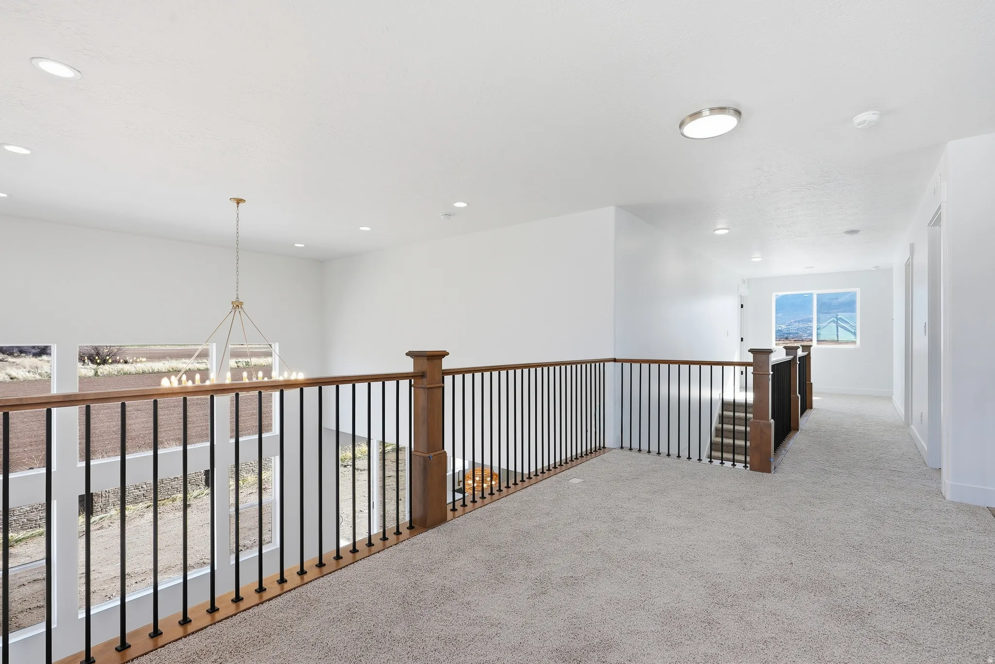 Hall featuring light carpet and suspended lighting